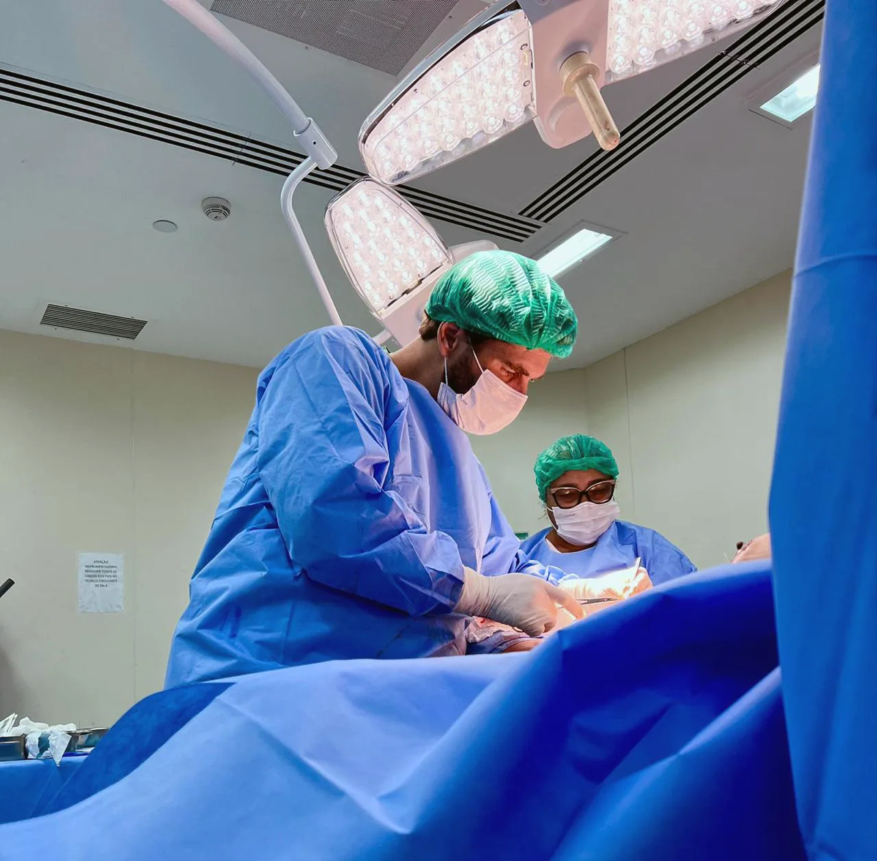 Dr. Orido Felipe durante procedimento cirúrgico em centro cirúrgico hospitalar.
